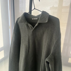 Grön fleece pikétröja från Zara - Säljer en skön grön fleece pikétröja från Zara. Tröjan har en klassisk krage och knappar framtill. Perfekt då våren börjat nalkats!