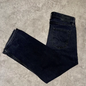 Svarta jeans från Jack & Jones - Säljer ett par baggy svarta jeans från Jack & Jones. De har en klassisk femficksdesign och knappgylf. Perfekta för en stilren look.