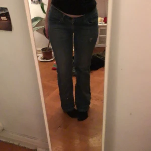 Blå jeans med curvy cut - Säljer ett par blå jeans med curvy cut. De har en klassisk femficksdesign och en bekväm passform. Perfekta för en avslappnad stil.