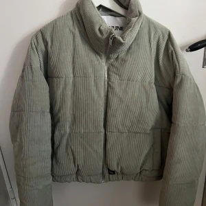 Grön manchesterjacka från Sixth June - Snygg grön manchesterjacka från Sixth June med dragkedja framtill. Jackan har en quiltad design och en hög krage för extra stil och värme. Perfekt för vårens dagar.