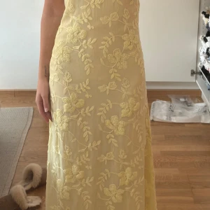 Ljusgul broderad bandeauklänning Moa Mattsons slutsålda Na-kd - Säljer en elegant ljusgul bandeauklänning med vackra blombroderier. Klänningen har en lång och flytande design som ger en romantisk känsla. Perfekt för speciella tillfällen. 🌼 oanvänd då jag beställde två storlekar💛Moa Mattson kollektion med na-kd, klänningen sålde slut på 1h💛