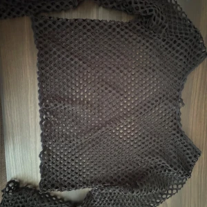 Svart nättröja - Säljer en unik svart nättröja med långärmad design. Perfekt för att lägga över en annan topp för en cool lager-på-lager-look. Tröjan har ett genomskinligt nätmönster som ger en edgy stil.