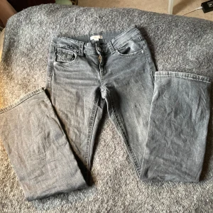 Grå jeans från Gina Tricot - Säljer ett par grå jeans från Gina Tricot. De har knappar på bakfickorna och en dragkedja fram. Bekväma och passar till allt. Säljer pga att de e för korta! 