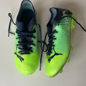 Gröna fotbollsskor från Puma - Obs!: kan gå ner lite vid snabbt köp. Hej, Säljer ett par grymma gröna fotbollsskor från Puma med svart snörning och logga. Skorna har en modern design med en lätt och flexibel sula, perfekt för snabba rörelser på planen. Skorna är kompatibla för att köra på naturgräsplaner och konstgräs. Andledning till att jag säljer dessa är att dem är för små i storleken fast när dem passa satt dem väldigt bra. Köpta för strax över 1000 kr 