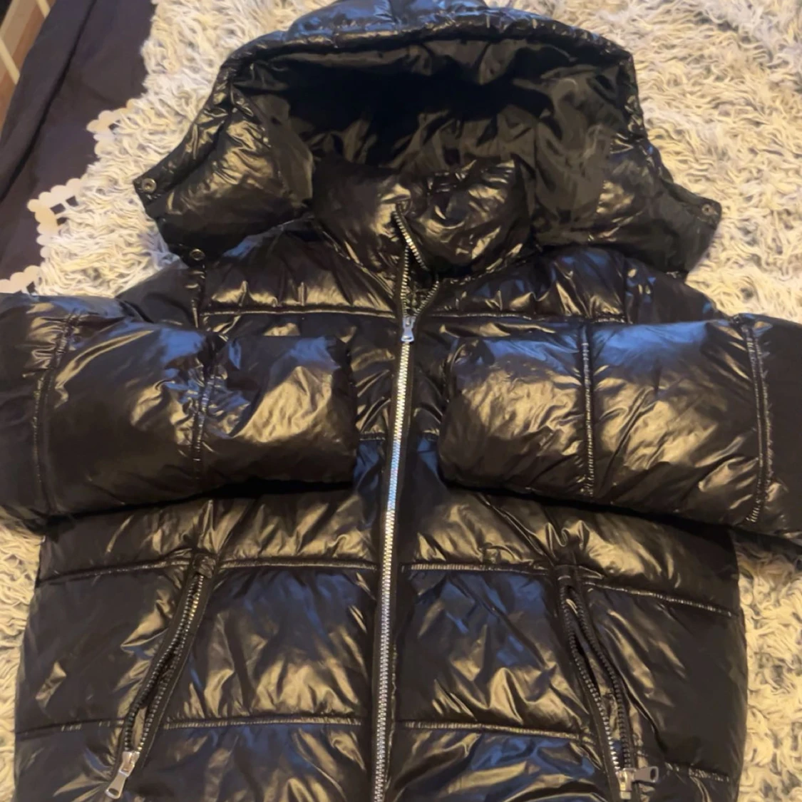 Svart glansig pufferjacka med luva
