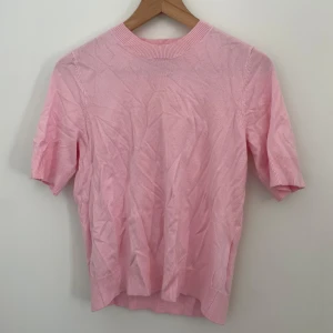 Rosa tröja från 157 - Säljer en söt rosa tröja från 157. Den har korta ärmar och en rund halsringning. Tyvvär är den lite skrynklig då den tyvvär bara kom till användning en gång och därför har legat i garderoben ett tag. Men det går självklart att stryka!