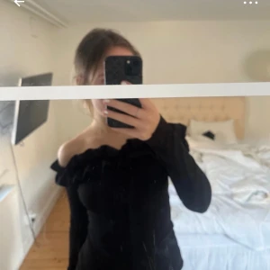 Svart offshoulder tröja me volang  - Storlek S tror jag! Snugg o stilren 