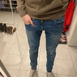 Blå jeans från Replay storlek 30 - Snygga blå jeans från Replay i modellen Anbass. De har en klassisk design och är i storleken 30/30 i passformen slim. Perfekta för en stilren look. Och passar till allt.