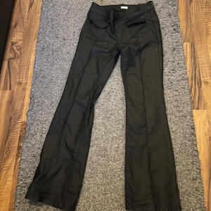 Svarta byxor med bootcut - Snygga svarta byxor med bootcut och låg midja från Nelly💕 Byxorna har fickor fram och bak samt knappar och dragkedja framtill. Perfekta för en stilren look💕 Jag säljer dem eftersom dem är lite för stora för mig🥰 