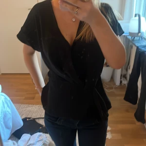 Svart topp  - Snygg svart topp med korta ärmar och knytning i midjan från Zara. Säljer då den inte kommer till användning. Använt några gånger men inga fel på den. Skriv om ni har fler frågor🥰