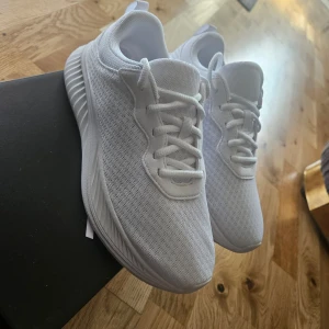 Vita sneakers med snörning - Snygga vita sneakers med en stilren design och snörning. Skorna har en tjock sula som ger bra stöd och komfort. Perfekta för en avslappnad stil.