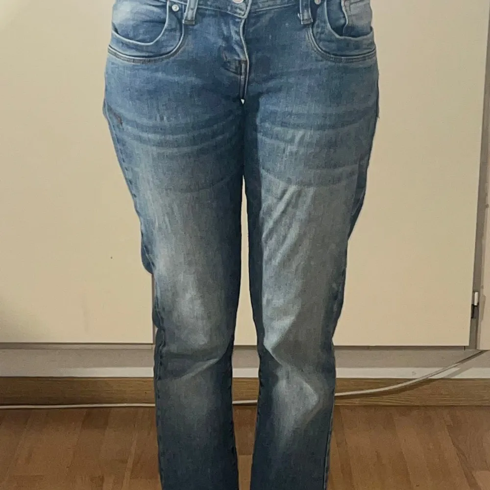 Säljer ett par snygga blå jeans från LTB. De har en klassisk femficksdesign och en knappgylf. Jeansen är i en straight passform och har en lätt tvättad look som ger en avslappnad stil.. Farkut & Housut.