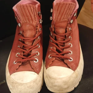Röda Converse All Star med Gore-Tex - Säljer ett par röda Converse All Star boots med Gore-Tex. Skorna har snörning och en robust vit sula. De är tillverkade i skinn och har en ribbad detalj på plösen. Perfekta för höst och vinter med sin vattentäta funktion. Behöver en tvätt så är dom så gott som nya 