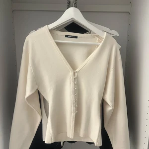 Vit v-ringad tröja från Gina Tricot - Säljer en  vit tröja från Gina Tricot med v-ringning och knappar framtill. Jag har aldrig använt tröjan! 