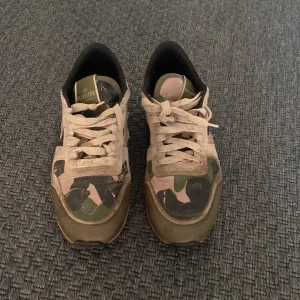 Camouflage sneakers från Valentino - Pris kan diskuteras. Mockan kommer tvättas. Fråga om mer bilder om ni vill .Snygga sneakers från Valentino garvani. Äkta . Använt i 2 månader. Bra skick . Nypris 5500kr. Säljer de för 1850 väldigt bra pris . Man kan använda de året runt och kan vara perfekt för en bra present till barn. 