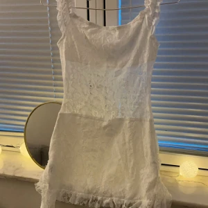 Vit spetsklänning med volang - Söt vit kortklänning med spetsdetaljer och volang längst ner. Tunn och lätt i materialet🧚🏽