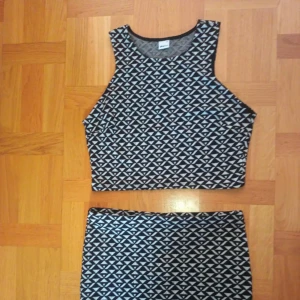 Svartvit croppad linnetopp och kjol från Gina Tricot - Säljer en croppad svartvit linnetopp och en tillhörande kjol från Gina Tricot med geometriskt mönster. Toppen är ärmlös och har en hög halsringning och perfekt att matcha med någon annan kjol eller jeans för en cool look om man vill de. 