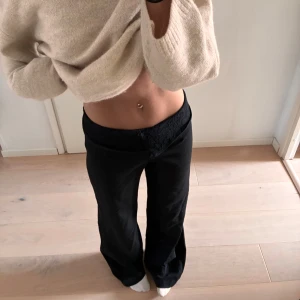 Svarta byxor med spetsdetalj - Design by si kostymbyxor!!! Säljer ett par svarta byxor med snygg spetsdetalj i midjan. Byxorna har låg midja och en rak passform som sitter skönt på kroppen. 