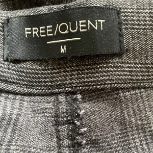 Mjuka, stretchiga byxor strl M från FREEQUENT  - Ett par Supersköna byxor från FREEQUENT i strl M. De är mycket stretchiga och sitter väldigt bra. Tyget är mönstrat och syns bäst på bild 3 där lappen sitter förutom att de är mörkare i tyget så som bild 1 och 2. Mycket bra skick. Katter finns i hemmet