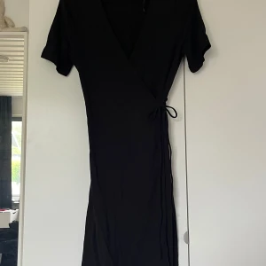 Omlottklänning  - Svart omlottklänning från Vero Moda i storlek S. Oanvänd och säljer då den inte passar. Bandet går runt ryggen och sen knyter man på framsidan. Väldigt mjukt material. Pris är diskuterbart  Hör av dig vid frågor