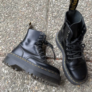 Svarta Dr. Martens Jadon boots med platåsula - Säljer ett par svarta Dr. Martens boots i skinn med  platåsula och klassisk gul söm. Skorna har snörning framtill och rund tå. Perfekta för dig som vill ha en edgy och tidlös stil. Nästan oanvända