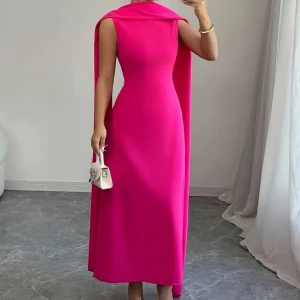 Ceriserosa långklänning med cape/sjal detalj - Oanvänd ceriserosa ärmlös långklänning. Kortärmad klänning med en lös rosa sjal som kan stylas hur man vill. Rund halsringning. I stolek M men passar även storlek S