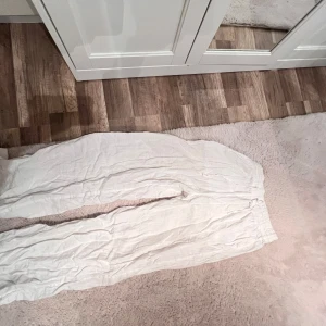 Vita linnebyxor från Gina Tricot - Säljer ett par luftiga vita linnebyxor från Gina Tricot i storlek 34. Byxorna har resår i midjan och är raka i modellen, ganska tunna o sköna till en varm dag. 