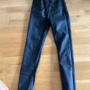 Svarta byxor från Stradivarius - Säljer ett par svarta byxor från Stradivarius i storlek 34. Skinny byxor med skinn imitation 