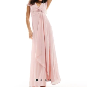 Ljusrosa långklänning med drapering - Elegant ljusrosa långklänning med draperad detalj framtill och smickrande passform. Oanvänd