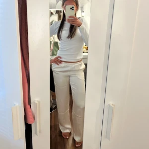 Creme vita satin byxor  - Creme vita satin byxor ifrån bikbok i strl XS men passar på mig som vanligtvis har S. Helt nya med prislapp på