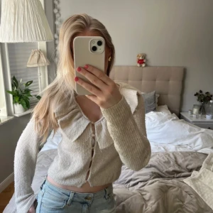 Stickad tröja med volang  - Säljer denna supersöta stickade tröjan från hm. Den har en volang på framsidan och knappar💕