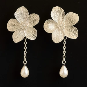 Blommiga örhängen med pärldetalj - Snygga örhängen i form av silverfärgade blommor med hängande kedja och vit pärla längst ner. Perfekta för att lyfta din outfit med en elegant touch och unik design.
