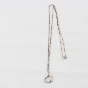 Silverhalsband med hjärthänge - Ett stilrent halsband i silver med ett öppet hjärta som hänge. Kedjan är tunn och elegant, perfekt för att ge en subtil touch till din look. Hänget har en mjuk, rundad form.