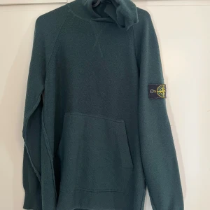 Stone Island hoodie  - Grön stone island hoodie stickad i mörkgrönt  i bra skick. Kan skickas eller hämtas i centrala Karlstad. Scanna för äkthetsverifiering. Kom med bud! Storlek L men passar M också. 