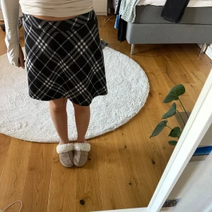 Svart och vit rutig kjol - Säljer en svart och vit rutig kjol med A-linjeformad passform. Kjolen är kort och har ett klassiskt rutmönster som passar perfekt till många olika stilar. Den är endast använd under 2 tillfällen. Den är från New yorker och är storlek M