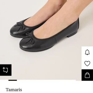 Svarta ballerinaskor med rosett från Tamaris - Klassiska svarta ballerinaskor från Tamaris i skinn med rund tå och en söt rosettdetalj framtill. Skorna har platt sula och en stilren design som passar till många olika outfits. HELT OANVÄNDA och ligger kvar i kartongen. Köpte dom för 699kr. 