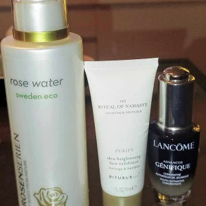 Hudvårdsprodukter från Rosenserien, Rituals och Lancomen, Rituals och Lancôme - Tre olika hudvårdsprodukter: en rosenvatten face mist från Rosenserien i vit flaska med gulddetaljer, en ansiktsskrubb från Rituals i vit tub och ett serum från Lancôme i svart glasflaska med pump. Perfekt för dig som vill ha glow och fräsch hy. 200kr plus porto för alla 3.