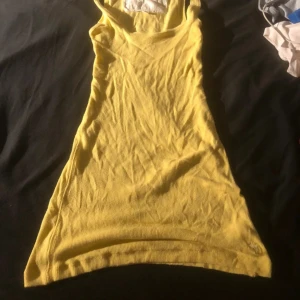 Gul ribbad linne Abercrombie & Fitch med prislapp - Säljer en söt gul ribbad Linne från Abercrombie & Fitch i storlek XS. Klänningen är ärmlös med smala axelband och har en broderad logga längst ner. Perfekt för varma dagar och har en slim passform som framhäver figuren.