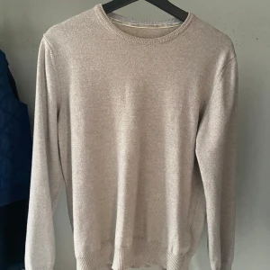 Beige stickad tröja från Stenströms  - Snygg beige stickad tröja från Stenströms. Tyvärr så krympte tröjan i tvätten så den passar storlek S istället för storlek L. Det finns också ett hål på armbågstyget och lite mindre defekter. Hör av er vid minsta fundering!