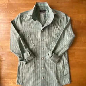 Grön rutig skjorta Riley slim fit - Snygg grön och vit rutig skjorta från Riley i slim fit-modell. Skjortan har klassisk krage, långa ärmar och vita knappar framtill. Tillverkad i mjuk bomull som känns skön mot huden. Perfekt för dig som gillar stilrena och fräscha mönster.