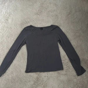 Grå långärmad topp från SHEIN - Snygg grå långärmad topp från SHEIN i storlek Petite S. Enkel och stilren design med rundad halsringning, perfekt att matcha med jeans eller kjol. Materialet känns mjukt och lätt mot huden, vilket gör den skön att bära hela dagen.