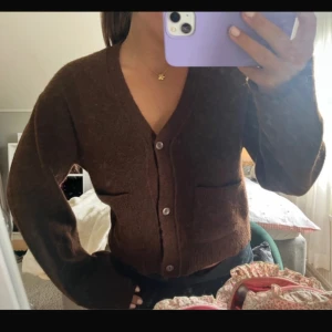 Brun kofta med knappar  - Mysig brun kofta från H&M Divided i storlek S. Koftan har v-ringning, två framfickor och knappar framtill. 