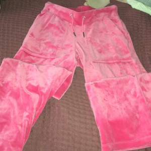 Rosa mjukisbyxor med snörning - Säljer ett par chill rosa mjukisbyxor i mjukt och glansigt velourmaterial. Byxorna har bred resår i midjan, snörning med metalländar och stora fickor både fram och bak. Perfekta för att hänga hemma eller dra till kompisar i.