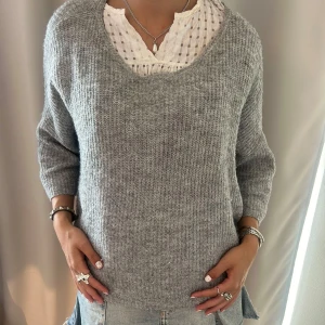 Grå loose stickad tröja - Säljer en grå stickad tröja med loose passform och bred v-ringning. 
