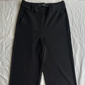 Svarta kostymbyxor Vero Moda - Snygga svarta kostymbyxor från Vero Moda i storlek XXS. Byxorna har klassisk rak passform och lite baggy, bälteshällor och sidfickor. Stängs med dragkedja, knapp och hake fram. Perfekta för en clean och stilren look. Gjorda i polystan och lite elastan. De är i väldigt bra skick, hela o rena. Pris kan diskuteras
