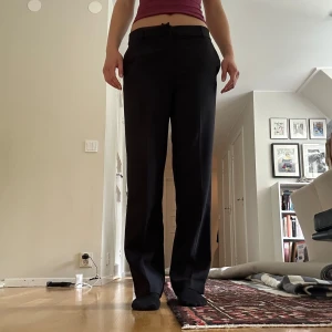 Svarta kostymbyxor från Gina tricot  - Snygga svarta kostymbyxor med breda ben och lowrise passform. !Materialet känns mjukt och har en lätt stretch. Perfekta till skolan och jobb