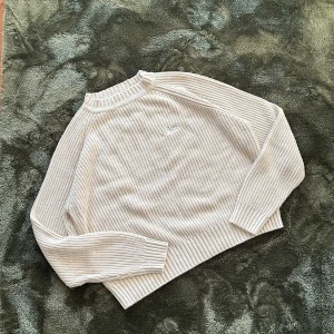 Beige stickad tröja från Corteiz - Säljer en beige stickad tröja från Corteiz med ribbad struktur och broderad logga på bröstet. Tröjan har långärmade raglanärmar och en hög, ribbad krage som ger en chill och clean look. Perfekt för dig som gillar stilrena och bekväma plagg. köpt från själva hemsidan Crtz så kvittot finns också!