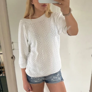 Vit stickad tröja med trekvartsärm - Säljer en vit stickad tröja med snyggt hålmönster och bred ribbad halsringning. Tröjan har ingen lapp men jag uppskattar den som storlek M. 