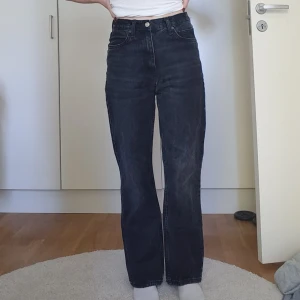 Svarta wide jeans från Zara, strl 36 - Säljer ett par svarta jeans från Zara i storlek 36. Modellen är wide med hög midja och raka ben. Är gjorda i ett slitstarkt material. Lapp med tvättråd och info om material är bortklippt.