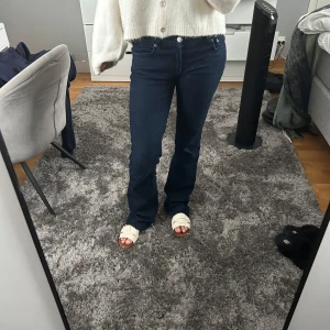 Mörkblå bootcut jeans - Säljer ett par slutsålda snygga mörkblå jeans från Zara med bootcut passform och låg midja. Jeansen är i storlek 36 och är lite slitna längst ner på ena benet, annars är de som nya. 